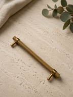 Brushed brass knurled cabinet handle installed on cabinet