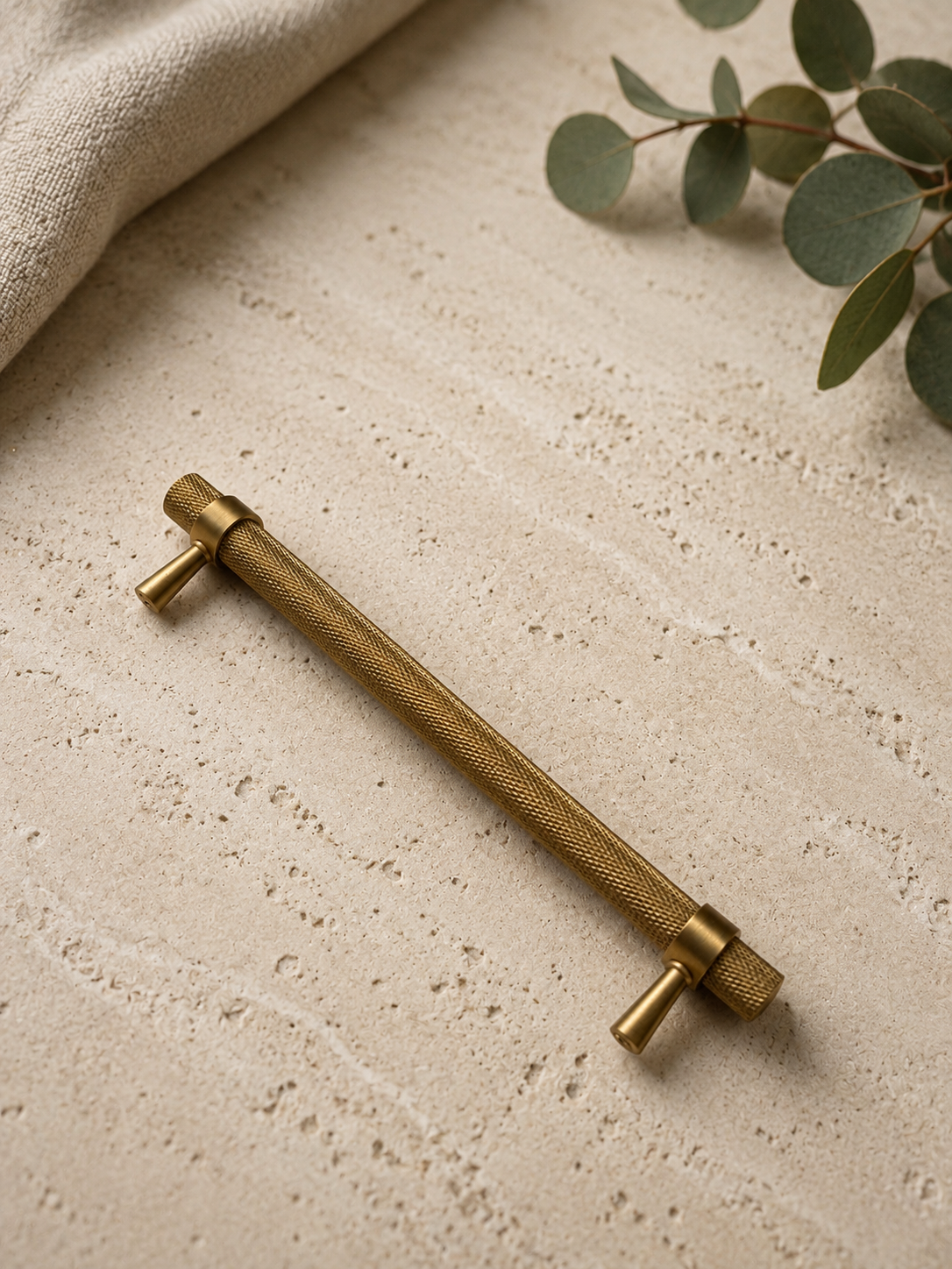 Brushed brass knurled cabinet handle installed on cabinet